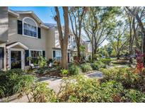 Townhouse exterior with landscaped walkway and lush greenery at 2155 Fox Chase Blvd, Palm Harbor, FL 34683