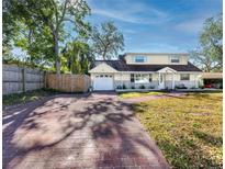 Ranch home features a brick driveway and mature landscaping at 11624 Pinedale Ave, Seminole, FL 33772