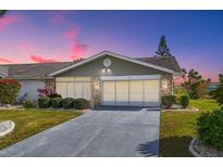 Charming single-story home featuring a stone-accented facade and a well-manicured lawn at 1321 Bluewater Dr, Sun City Center, FL 33573