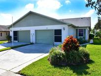 Two-unit building exterior with attached garages and landscaping at 3270 Mcmath Dr, Palm Harbor, FL 34684