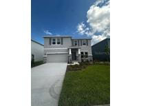 Charming two-story home with gray facade, landscaped yard and a two car garage at 16021` 7Th E Ave, Bradenton, FL 34212