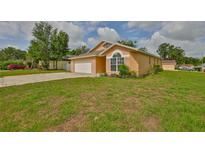 Charming single-story home with a manicured lawn, attached garage, and neutral paint at 311 Sugar Creek Dr, Plant City, FL 33563
