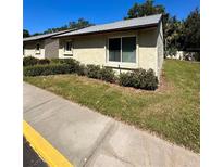Tan house exterior with a well-manicured lawn and sidewalk at 4215 E Bay Dr # 1013B, Clearwater, FL 33764