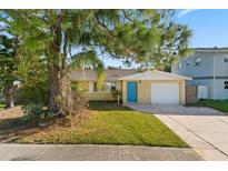 One-story home with teal front door, attached garage, and landscaped yard at 5419 Denver Ne St, St Petersburg, FL 33703