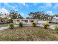 Ranch-style home with attached two-car garage and palm trees at 615 16Th Nw St, Largo, FL 33770