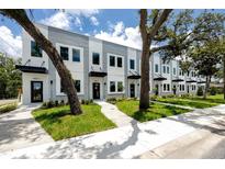 Modern townhome exterior featuring a well-manicured lawn and a stylish black awning over the front door at 3402 E 28Th Ave # 1, Tampa, FL 33605