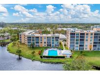 Aerial view of the community with a pool and lake at 4530 Pinebrook Cir # 208, Bradenton, FL 34209
