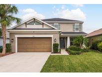 Two story house with brown garage door and landscaping at 8011 Marbella Creek Ave, Tampa, FL 33625