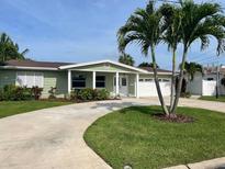 Charming single-story home with a well-manicured lawn, circular driveway, and attractive landscaping at 4086 13Th Ne Ln, St Petersburg, FL 33703