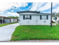 Quaint single-wide manufactured home with a well-maintained lawn at 36338 Coronado Way, Zephyrhills, FL 33541