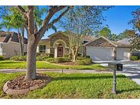 House exterior featuring stone accents and a three-car garage at 16183 Colchester Palms Dr, Tampa, FL 33647