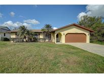 Yellow ranch home with attached garage and large yard at 18138 Lake Worth Blvd, Port Charlotte, FL 33948