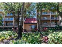 Exterior view of a condo building with lush landscaping at 3078 Eastland Blvd # 304, Clearwater, FL 33761