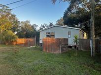 Mobile home with fenced yard and mature trees at 9131 Kosimo St, New Port Richey, FL 34654