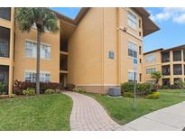 Condo building exterior with walkway and landscaping at 4305 Bayside Village Dr # 104, Tampa, FL 33615