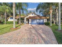 Beautiful home with tile roof, blue garage door, and brick driveway at 5479 Blue Heron Ln, Wesley Chapel, FL 33543
