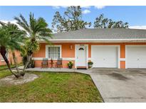Orange duplex with a two-car garage and well-maintained lawn at 3334 W Heiter St, Tampa, FL 33607