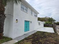 Charming two-story home featuring a striking teal-colored door and a well-maintained, newly painted exterior at 301 W Chelsea St, Tampa, FL 33603