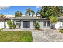 Single-story home with a dark blue door and landscaped yard at 4105 W Carmen St, Tampa, FL 33609