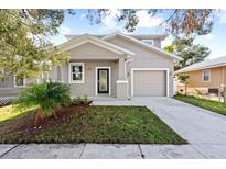Newly constructed home with gray siding, landscaping, and a two-car garage at 1815 E 22Nd Ave, Tampa, FL 33605