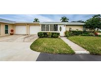 Tan house with attached garage, landscaped yard, and walkway at 2739 Sherbrooke Ln # B, Palm Harbor, FL 34684