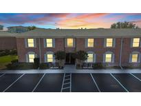 Brick condo building exterior at dusk with parking at 3970 37Th S St # 14, St Petersburg, FL 33711