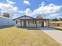 Newly renovated home featuring a modern facade, landscaped lawn, and driveway at 715 N Disston Ave, Tarpon Springs, FL 34689