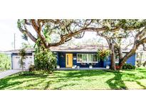 Charming ranch home with a vibrant blue exterior and yellow door at 130 63Rd S St, St Petersburg, FL 33707