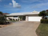 Single-story home with white garage door and landscaping at 212 Poinciana Ln, Largo, FL 33770
