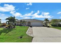 Single-story home with a two-car garage and landscaped yard at 26159 Constantine Rd, Punta Gorda, FL 33983