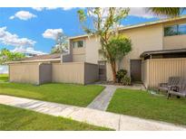 Tan townhouse with a small front yard at 8014 Peach Dr, Temple Terrace, FL 33637