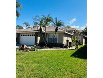 Single-story home with attached garage and palm trees at 1404 Woodstream Dr, Oldsmar, FL 34677