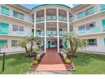 Oasis community building, featuring a teal and white color scheme, palm trees, and a walkway at 1900 59Th N Ave # 305, St Petersburg, FL 33714