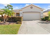 Tan house with two-car garage and landscaping at 1028 Orca Ct, Holiday, FL 34691