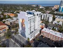 Aerial view of a modern white condominium building featuring a mural of a Personal on its facade at 226 5Th N Ave # 706, St Petersburg, FL 33701