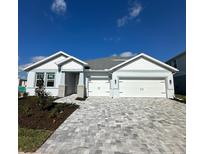 Two-story house with gray siding, white trim, and a paver driveway at 44862 Kelsa Anne Loop, Punta Gorda, FL 33982