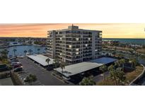 Stunning aerial view of a waterfront condo building with covered parking and boat docks, perfect for coastal living at 1651 Sand Key Estates Ct # 52, Clearwater, FL 33767