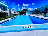 Community pool with lounge chairs and a surrounding patio area at 2060 Marilyn St # 239, Clearwater, FL 33765