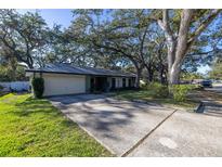 Ranch style home with carport and mature landscaping at 2227 Willowbrook Dr, Clearwater, FL 33764