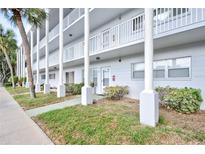 Exterior view of a light gray building with columns, showcasing a well-maintained property at 2450 Canadian Way # 6, Clearwater, FL 33763