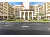 Exterior view of a multi-story building with parking and an entrance at 9000 Commodore Dr # 401, Seminole, FL 33776