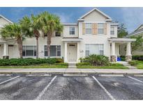 Two-story townhome with light beige siding, landscaping, and parking at 12352 Country White Cir, Tampa, FL 33635