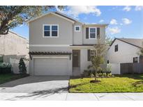 Two-story house with gray siding, a gray door, and a two-car garage at 3612 W Renellie Cir, Tampa, FL 33629