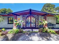 Inviting home exterior with a unique arched double door and lush landscaping at 1560 53Rd N St, St Petersburg, FL 33710