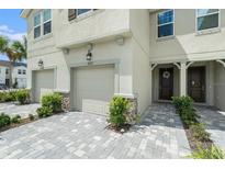 Two-story townhome with attached garage and landscaped walkway at 19157 Elsimont Isle, Lutz, FL 33558