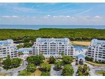 Aerial view of a waterfront condo building with lush landscaping at 2333 Feather Sound Dr # B101, Clearwater, FL 33762