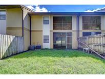 Private backyard with grass and wooden fence at 10100 Sailwinds N Blvd # 106, Largo, FL 33773