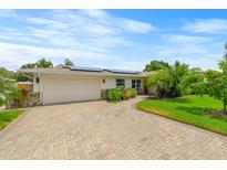 Ranch-style home with solar panels and brick driveway at 171 98Th N Ave, St Petersburg, FL 33702