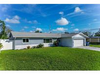 Ranch-style home with gray siding, white trim, and a two-car garage at 6701 13Th N Ave, St Petersburg, FL 33710