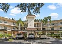 Front view of a two-story residential building with covered parking at 820 Virginia St # 207, Dunedin, FL 34698